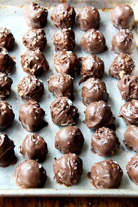 A sheet pan lined with chocolate covered peanut butter balls.