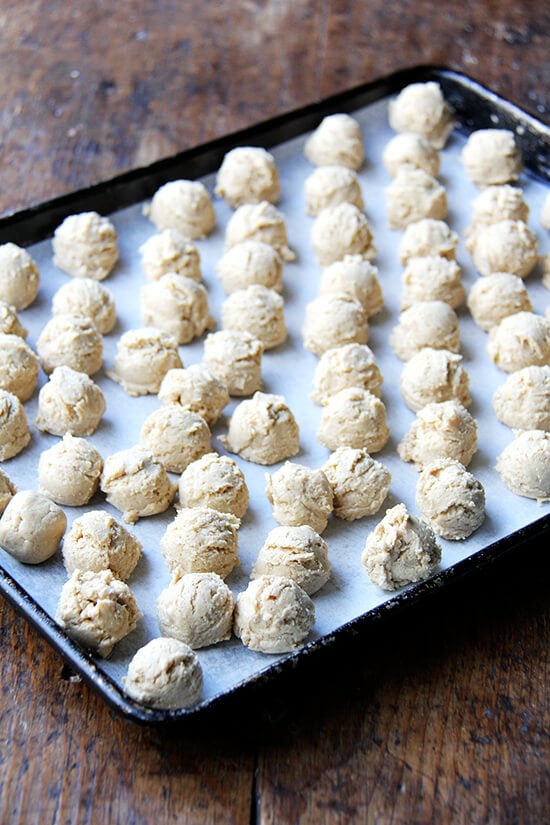 A sheet pan lined with scooped peanut butter balls. 