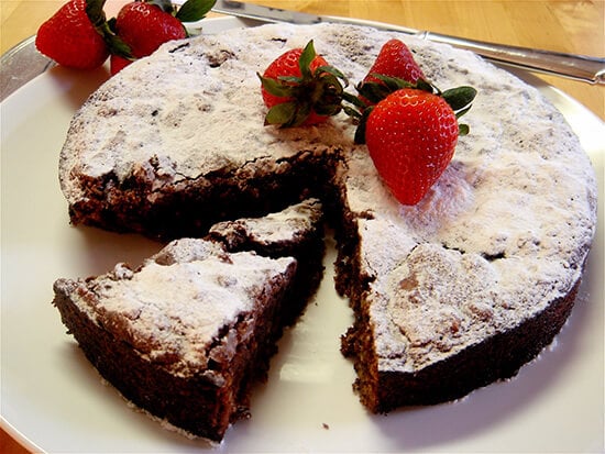 This rich Passover chocolate cake rises dramatically, cracks and then falls. When dusted with Passover “confectioners’ sugar” and garnished with berries, the cake looks striking on the table. // alexandracooks.com