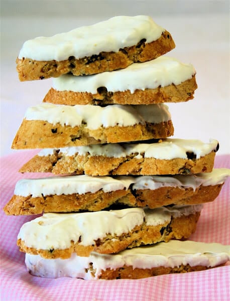 A stack of pistachio-cranberry biscotti dipped in white chocolate.