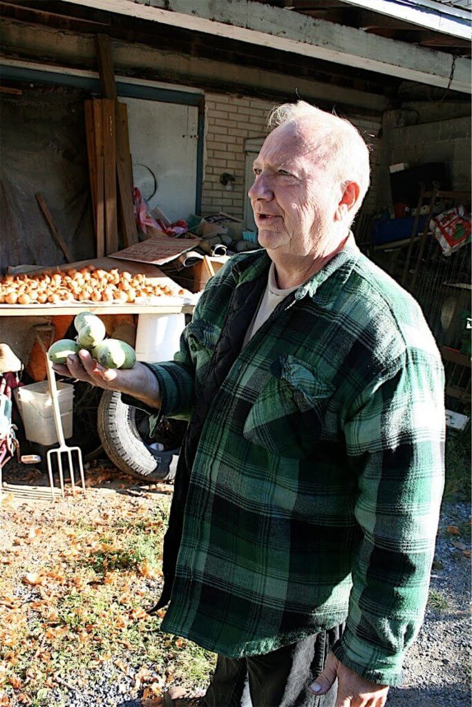 Sam Consylman holding a bundle of pawpaws.