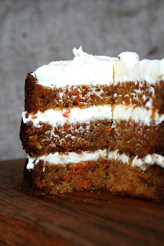 A sliced carrot cake on a board.