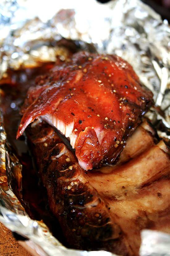 Cooked ribs lying in tin foil just out of the oven