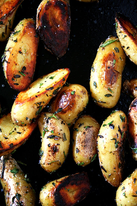 A cast iron skillet filled with crispy fingerling potatoes. 