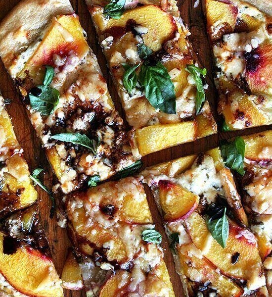 Just-baked nectarine pizza sliced into pieces.