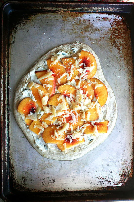 Assembled nectarine pizza on a sheet pan. 