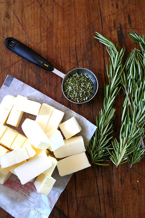 Ingredients for rosemary shortbread on a board: butter + rosemary. 