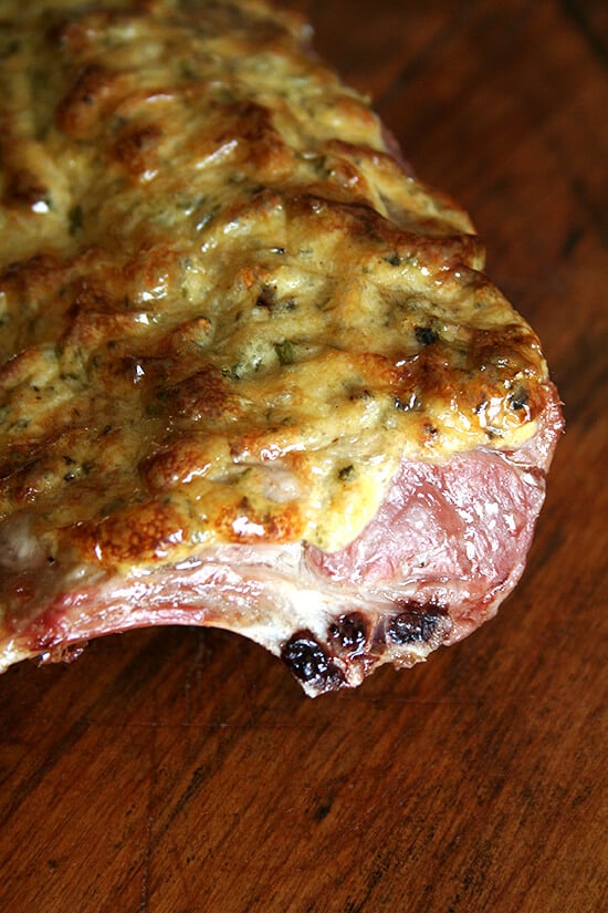 Cooked rack of lamb, resting on a board. 