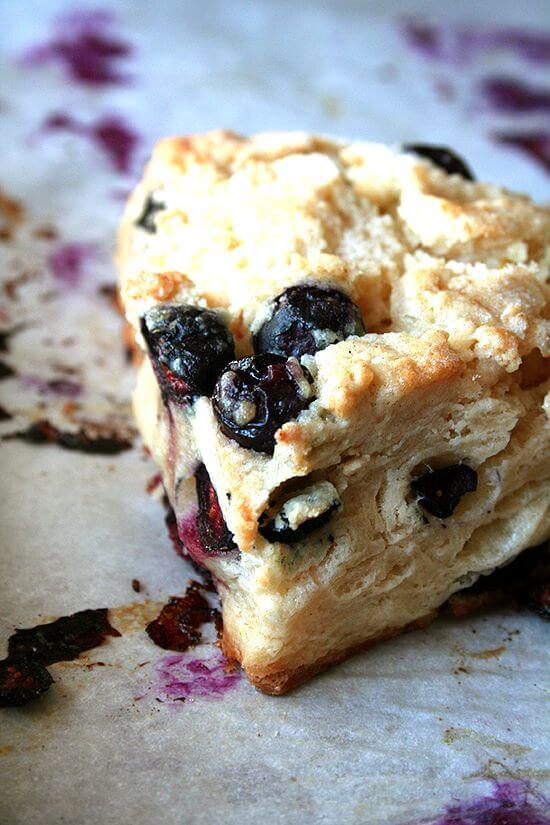 Up close shot of a buttermilk blueberry scone on a sheet pan. 