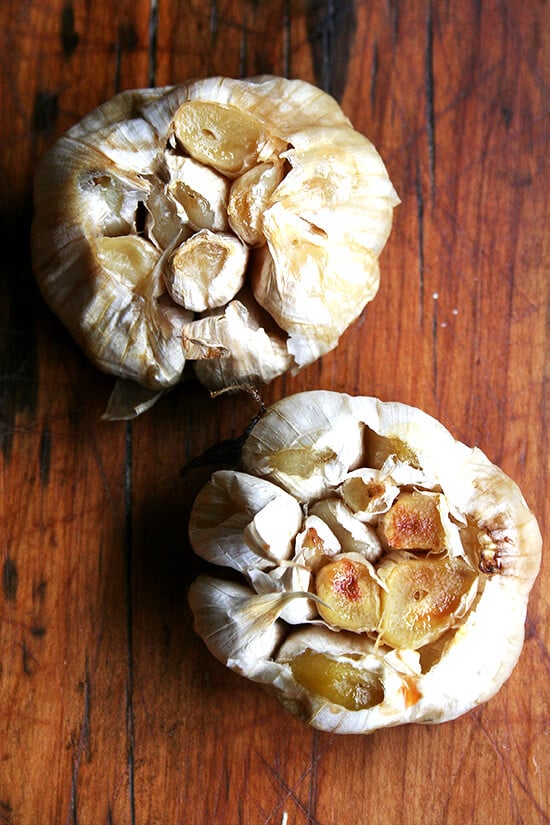 An overhead shot of two heads of roasted garlic. 