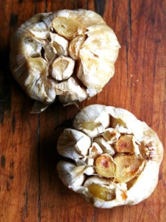 An overhead shot of two heads of roasted garlic.