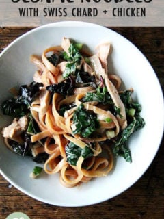 A bowl of sesame noodles with swiss chard.