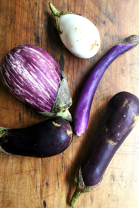 Five eggplants from our CSA on a board.