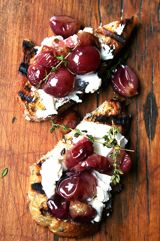 This recipe for thyme-roasted grapes with ricotta and grilled bread couldn't be more simple or delicious. Thyme-infused roasted grapes atop grilled bread spread with homemade ricotta makes for a delectable lunch, hors d'oeuvres, or side dish. // alexandracooks.com