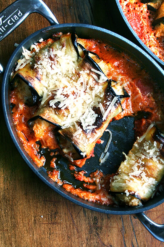 a pan of eggplant involtini with one involtini eaten