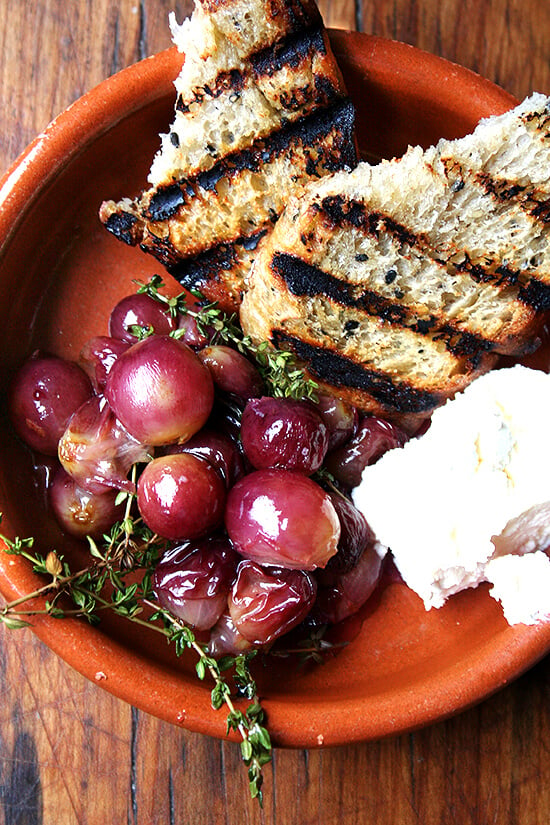 This recipe for thyme-roasted grapes with ricotta and grilled bread couldn't be more simple or delicious. Thyme-infused roasted grapes atop grilled bread spread with homemade ricotta makes for a delectable lunch, hors d'oeuvres, or side dish. // alexandracooks.com