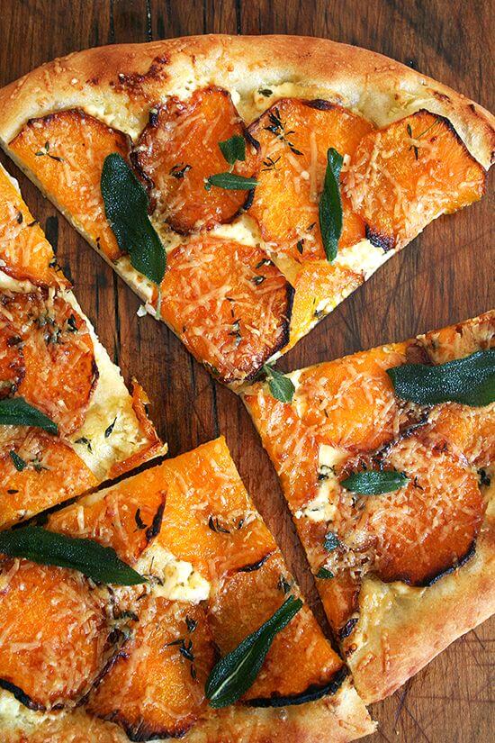 A roasted butternut squash and crispy sage pizza cut into wedges.