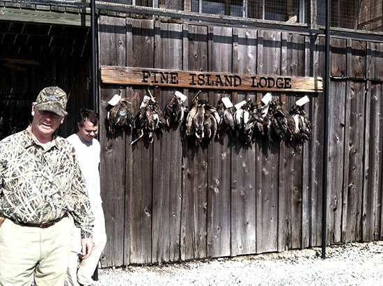 A wall of Pine Island Lodge with killed wild ducks hanging from hooks. 