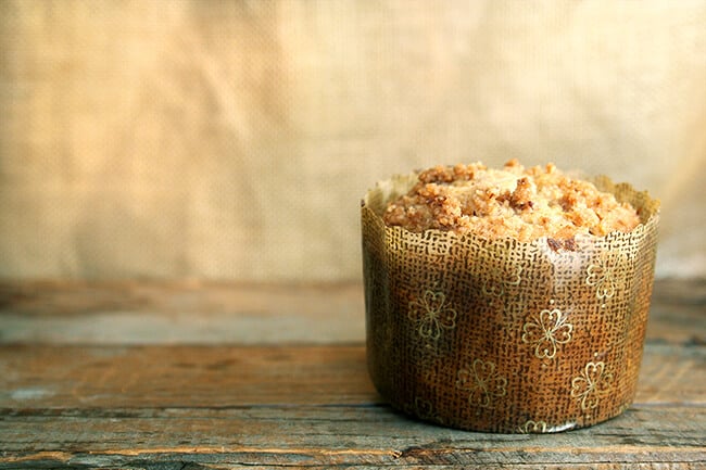 A coffeecake muffin in a decorative paper liner. 