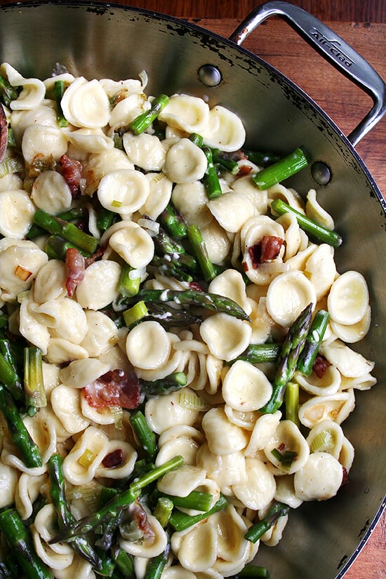 A pan of pasta carbonara with asparagus. 