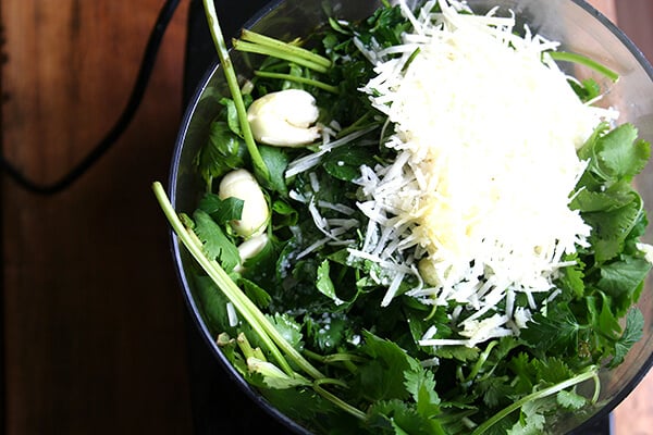 A food processor filled with pesto sauce ingredients. 