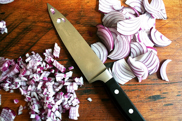 How to cut an onion into perfect little arched diamonds which make the prettiest additions to salsa, potato salad, whole grain salads and bean salads etc. The key is in the final slicing step: when the half moon slices of onion are stacked, and you are ready to start creating your dice, you always want to keep your knife 90º to the curve. // alexandracooks.com