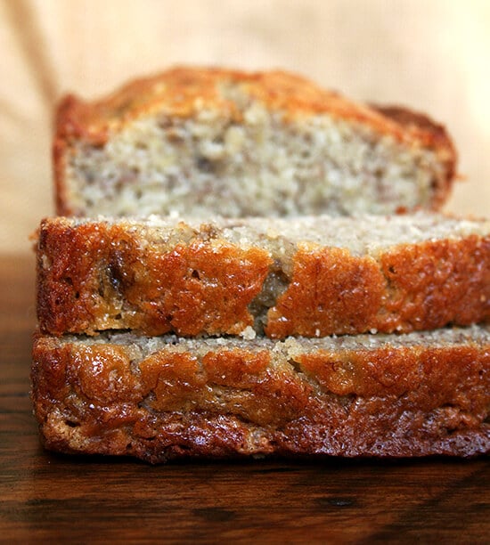 Close-up side view of two slices of moist banana bread on a cutting board