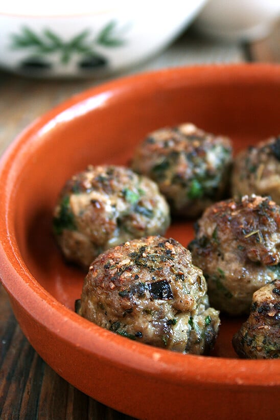 Lamb meatballs, loaded with mint and parsley, broiled, sprinkled with vinegar in a small plate.