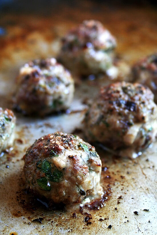 A sheet pan of broiled lamb meatballs.