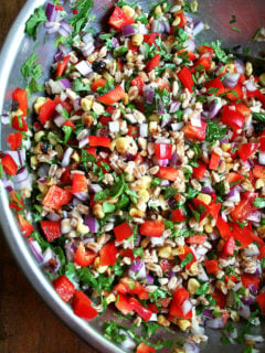 This farro salad, a combination of roasted corn, fresh-squeezed lime juice, cilantro, minced chili peppers and diced peppers and onions, has become a weekly staple. If you strategize by chopping the vegetables and herbs while the corn is roasting and the farro is simmering, this salad can come together in just about 20 minutes. It yields a lot, thanks to all of the add-ins, and tastes better with each passing day. // alexandracooks.com
