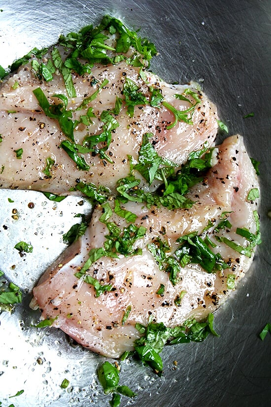 uncooked chicken breasts seasoned with basil, salt and pepper