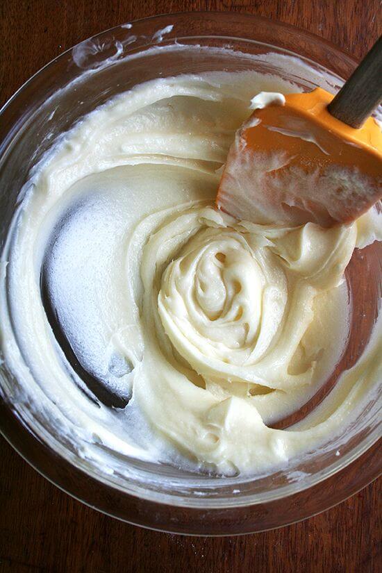  A glass bowl filled with cream cheese frosting. 