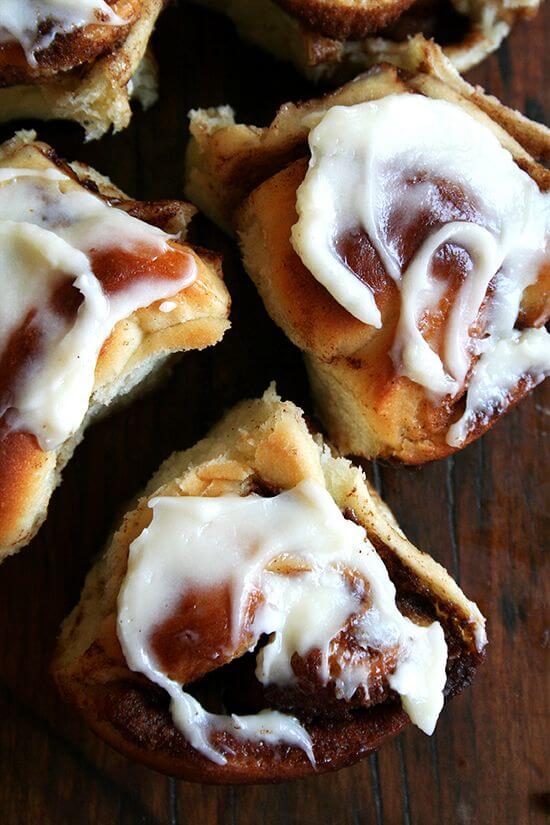 An overhead shot cinnamon rolls topped with cream cheese frosting. 