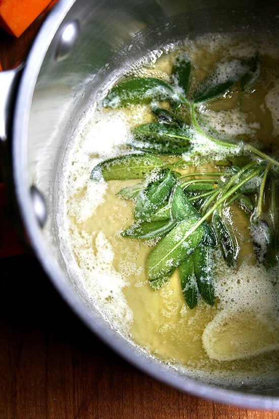 A saucepan with sage and melted butter.