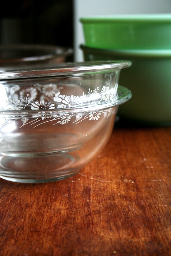 Two pyrex bowls stacked on wooden surface