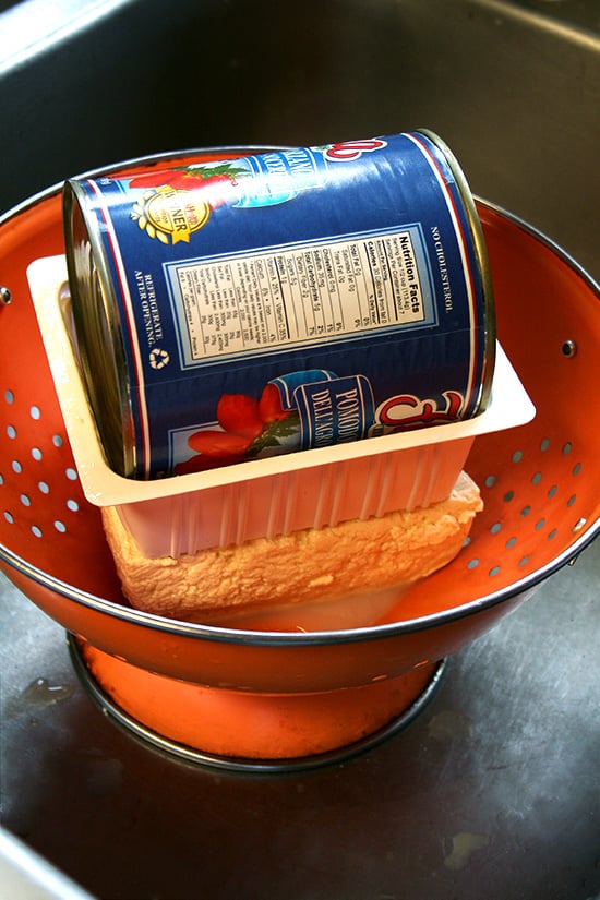 draining the tofu in a sink with a colander