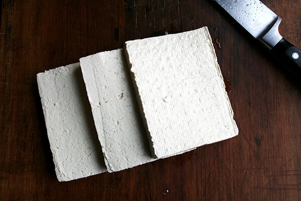 A block of tofu, sliced into thirds. 