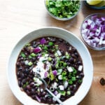 A bowl of black bean soup with all of the garnishes.