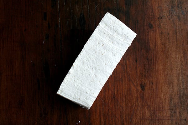 tofu block, ready to be cut into thirds