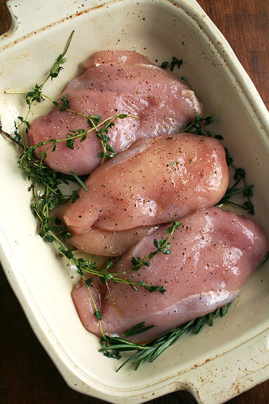 Three chicken breasts in a roasting pan. 