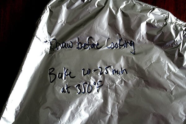 Pasta dish, ready for the fridge or freezer, covered in foil with instructions written in black Sharpie. 