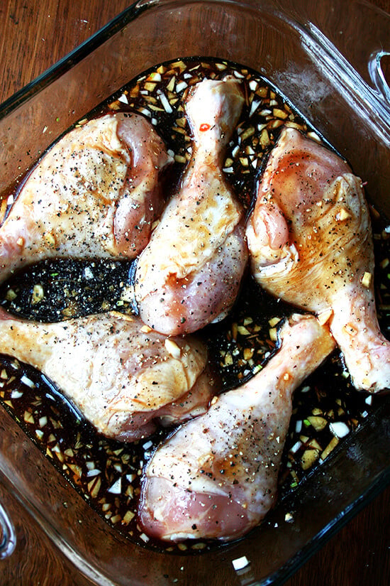 Chicken drumsticks in baking dish, covered in soy sauce mixture. 