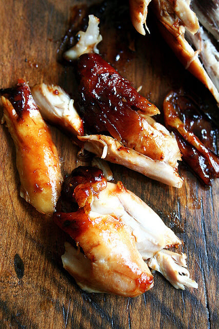 Honey-soy chicken drumstick, cut up on cutting board. 