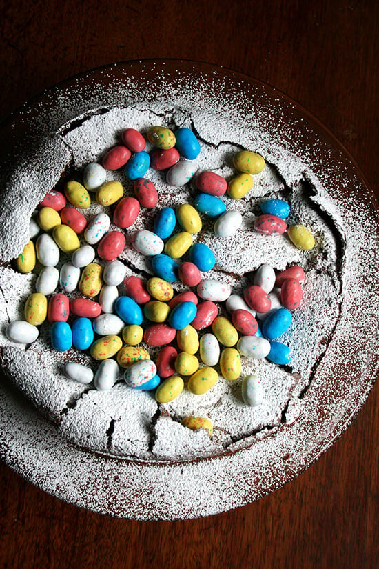 This rich chocolate Easter egg nest cake is festive and fun, puffing way up when it bakes and sinking when it cools, a crackly meringue-like layer forming a perfect base to house dozens of colorful candy eggs. // alexandracooks.com