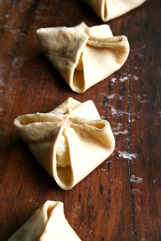 Four pinched cheese danishes, ready for their second rise. 