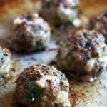 A sheet pan of broiled lamb meatballs.