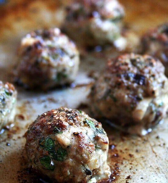 A sheet pan of broiled lamb meatballs.