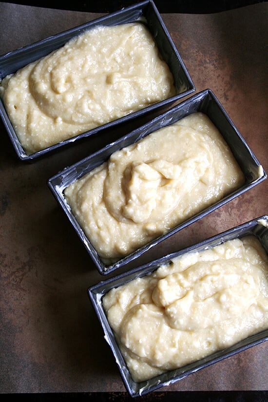 Three mini loaf pans filled with lemon-ricotta pound cake batter. 