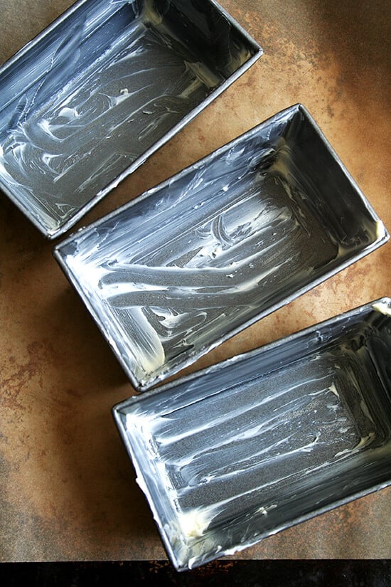 Three buttered mini loaf pans.