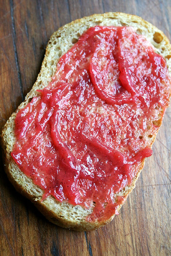 A slice of homemade peasant bread spread with homemade rhubarb jam. 